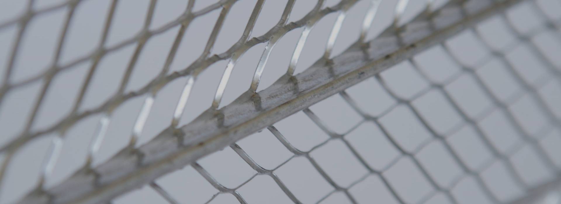 A detail of metal rib lath on gray background.